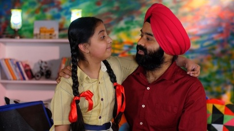 A young schoolgirl with braided hair talking to her father before going to school - father-daughter bonding