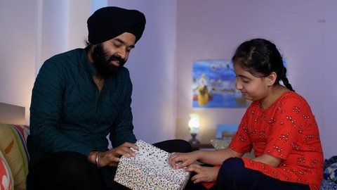 A North Indian Sardar and her adorable daughter opening a gift box together - a birthday gift, a surprise gift